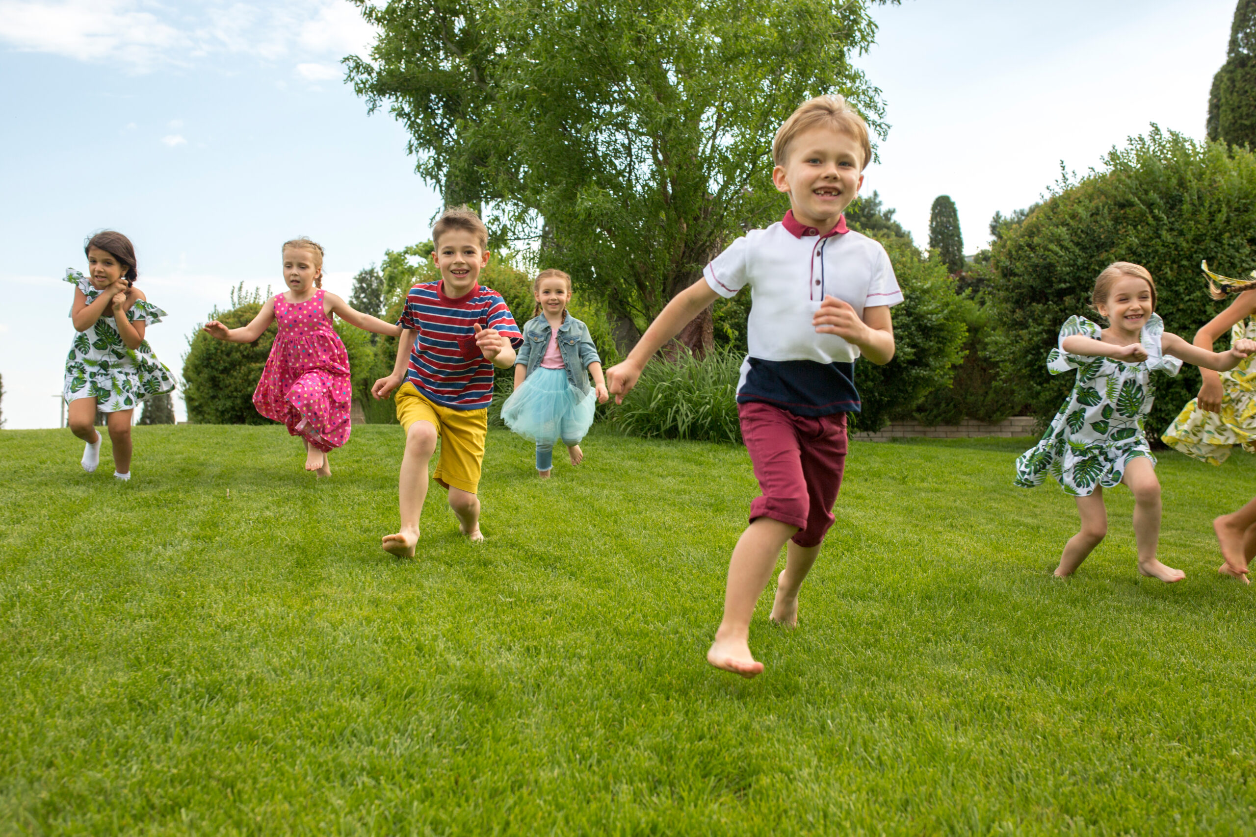 Kids fashion Concept Funny starts. Kids fashion concept. The group of teen boys and girls running at park. Children colorful clothes, lifestyle, trendy colors concepts.